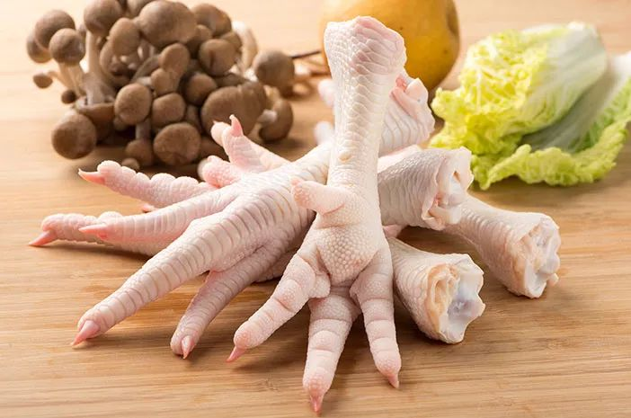 Raw chicken feet on white background