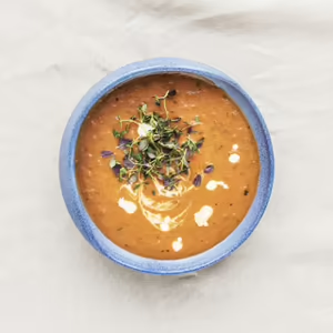 Bowl of chicken soup with herbs on white background